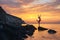 The silhouette girl on a rocky beach, against the dawn, in the pose of a jumping ballerina on stage, with outstretched wings in