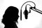 Silhouette of a girl with a studio microphone, radio presenter, singer and blogger, voice acting