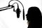 Silhouette of a girl with a studio microphone, radio presenter, singer and blogger, voice acting for films. Strong, black and