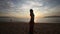 silhouette of girl who admires scenery of sunrise above sea