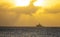 SILHOUETTE: Golden evening sky spans above a luxury yacht sailing across ocean