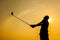 Silhouette of Golfer Drive Golf with Orange Background