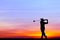 Silhouette golfer playing golf at beautiful sunset