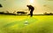 Silhouette golfer showing happiness when win in game , white golf ball on green grass with blur background.