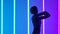 Silhouette of graceful young woman dancing elements of modern dance in the studio on a blue purple background with neon