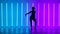 Silhouette of a graceful young woman in full growth dancing elements of modern dance in the studio on a blue purple