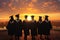 Silhouette of graduation students standing in a row with sunset background, rear perspective of a group of university graduates,