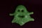 A silhouette of a green slime ghost on a black background. Design for halloween. The photo