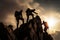 Silhouette of a group of climbers reaching the top of a mountain, Climbers helping another climber to climb up, Rear View, No