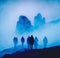 A silhouette of group hikers hiking in dold blue winter