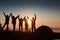 A silhouette of group people have fun at the top of the mountain near the tent during the sunset