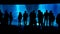 Silhouette group of people looking at an underwater blue aquarium with rocks