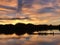 Silhouette group of people rowing on Long rowboat at river on beautiful twilight light evening sky clouds with sunset and silhouet