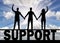 Silhouette of a group of people of three people holding hands stand on the word support