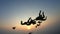 Silhouette of a group of skydivers jumping at the end of the day.