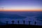 Silhouette group of tourists watch the view of star and milky way and foggy landscape on the top of the mountain and raise their h