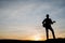 Silhouette of guitar player jump on stone