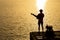 Silhouette of guitarist playing a guitar on the river under the