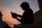 Silhouette of a guy with afro using his smartphone during sunset in the city center