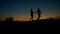 Silhouette of guy and girl walking on the hills.