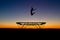 Silhouette of gymnast on trampoline in sunset