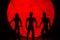 The silhouette of Halloween zombies decorations.There`s a red full moon in the background. Halloween horror concept