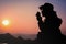 Silhouette Handsome man looking forward with binoculars at a mountain and drinking coffee