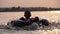 Silhouette of Happy Boy Swiming on inflatable Circle in the River at Sunset. Slow Motion