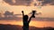 Silhouette of happy champion little boy child holding up golden trophy cup in hand