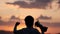 Silhouette of happy champion little boy child holding up golden trophy cup in hand