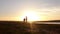 Silhouette, happy child with mother and father, family at sunset, summertime. Run, raising baby up in the air, hugs, love, playing