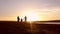 Silhouette, happy child with mother and father, family at sunset, summertime. Run, raising baby up in the air, hugs, love, playing