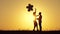 Silhouette of a happy couple in love. A girl with balloons runs to a man, hugging and kissing him at sunset. Happy