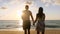 Silhouette of happy couple walking along beach to ocean surf