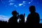 Silhouette of happy family sitting and looking sky at comets.