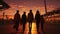 Silhouette of a happy family walking along the waterfront at sunset