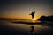 Silhouette of happy joyful woman jumping and having fun at the beach at sunset/sunrise.Freedom and happiness.Holiday vacation