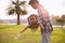 A silhouette of a happy young father harmonious family outdoors. laughing and playing in. the summer on the sunset background.