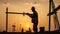 Silhouette of hardworking men on construction site at sunset