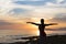 Silhouette healthy woman doing Yoga exercises on the beach in sunset time, Thailand.