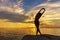 Silhouette healthy woman lifestyle exercising vital meditate and practicing yoga on the rock in beach at sunset.