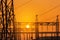 Silhouette high voltage electric pillars pylon in electric power plants substation on sunset