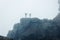 Silhouette of hikers on cliff edge with dense mist atmosphere