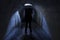 A silhouette of a hooded man in a dark underground tunnel near a hatch in the ceiling