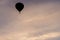 Silhouette of a hot-air balloon against a picturesque sky illuminated by the colors of the sunset