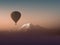 Silhouette hot air balloon flying over the mountains