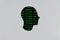 Silhouette of a human cardboard head cutout with a binary code made up of a set of green digits on a black background in its head