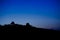 Silhouette of huts on a hill against twilight