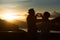 Silhouette of image of happy romantic senior couple making heart shape with hands outdoor at sunset background