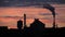 Silhouette of industrial building with smoking chimney